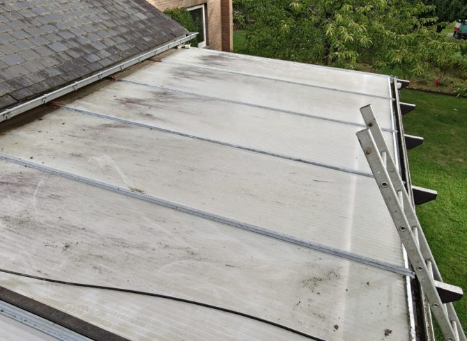 photo Avant le nettoyage de toiture de véranda en polycarbonate remplie de mousse et de lichen